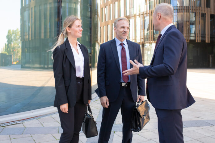 Confident professional adult businesspeople meeting outdoors